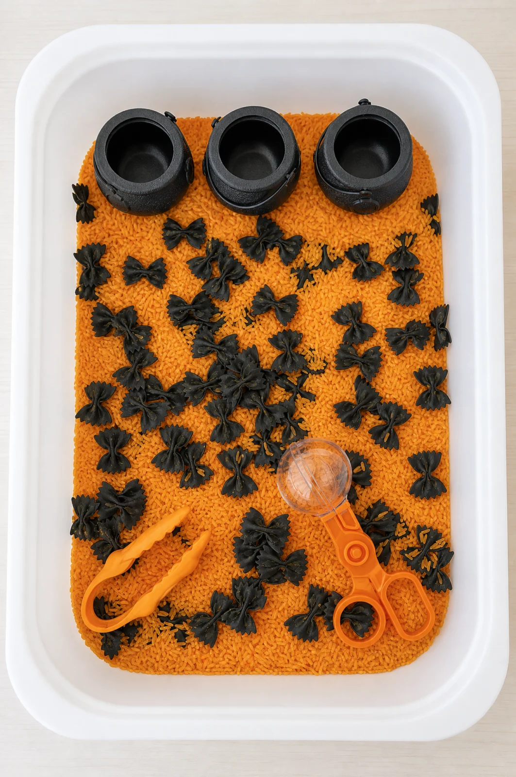 Witches Cauldron Halloween Sensory Bin with Colored Rice & Bowtie Pasta